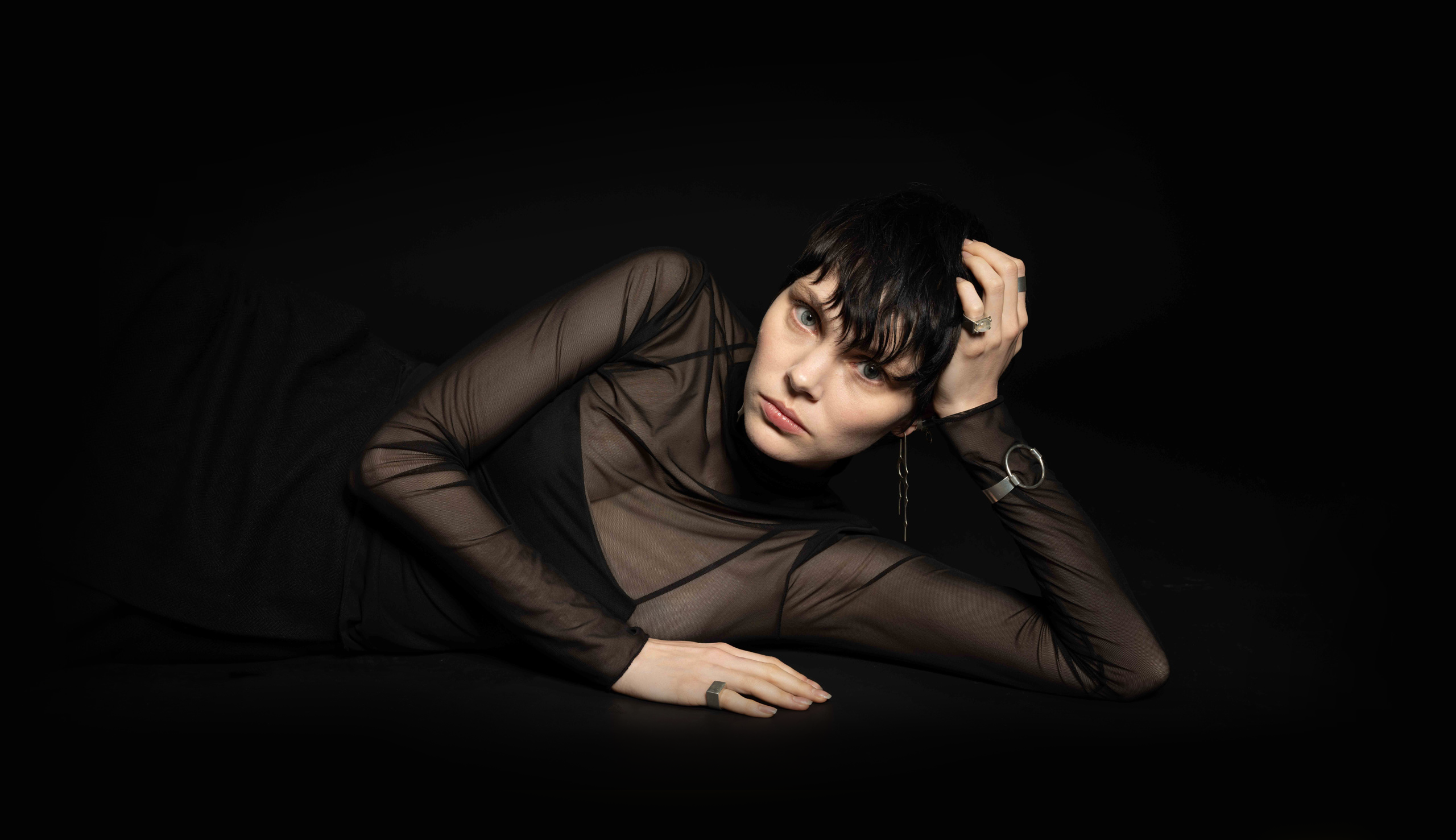 Minimal silver jewelry and leather accessories styled in a clean, modern editorial composition.